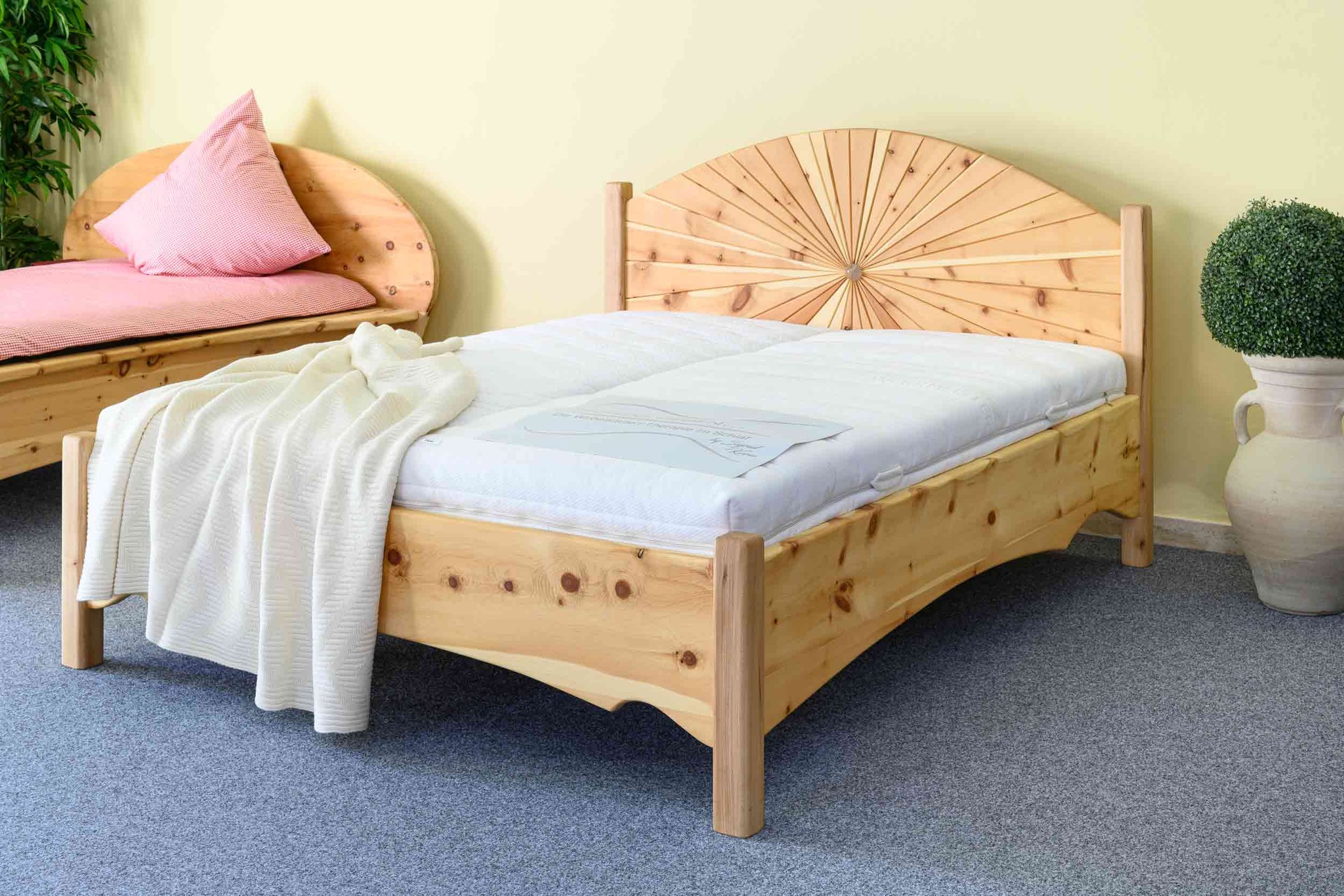 Handgefertigtes Zirbenholzbett mit Strahlen-Kopfteil im Showroom